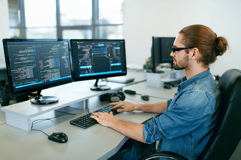 Programación. 在it办公室用电脑工作的人, 坐在写代码的办公桌前. 程序员编写数据代码, 在软件开发公司做一个项目. 高质量图像.